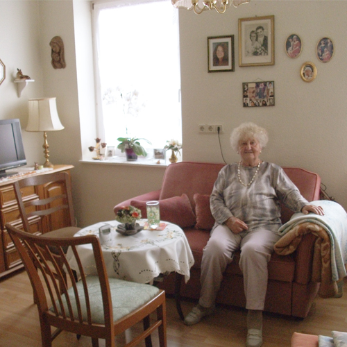 Tisch mit gemusterter Tischdecke und hellem grossen Fenster